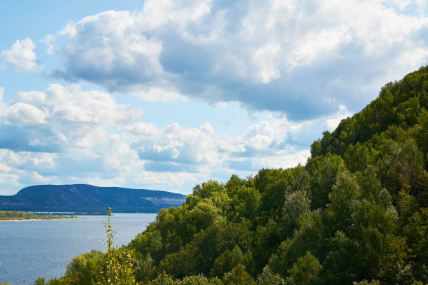 istock River against the blue sky with clouds and forest. 1065881226
