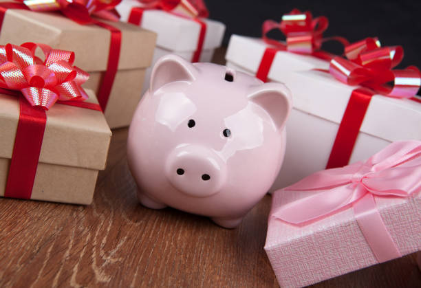 istock pink piggy bank with gift boxes with red bows close up 1065881676