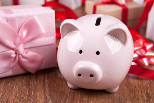 istock pink piggy bank with gift boxes with red bows close up 1065881694