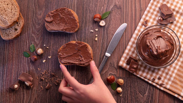 istock Slices of bread with chocolate cream nuts and knife. 1065884064