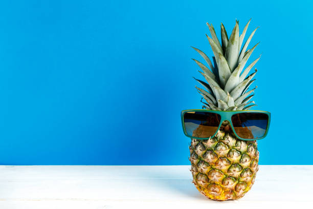 istock whole pineapple in sunglasses on blue background. 1065890272