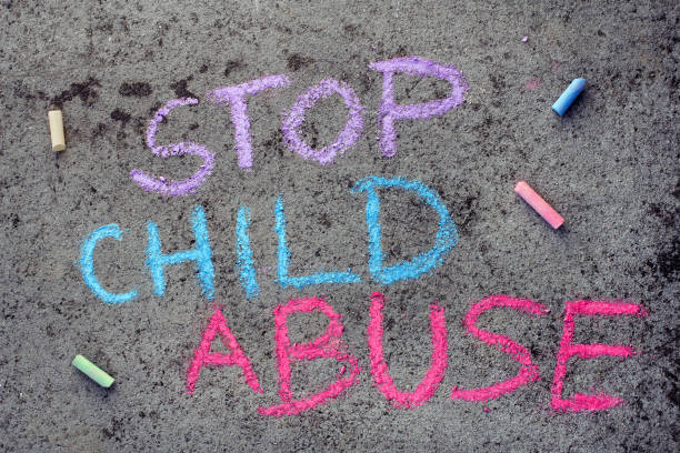 istock Colorful chalk drawing on asphalt: words STOP CHILD ABUSE 1065897596