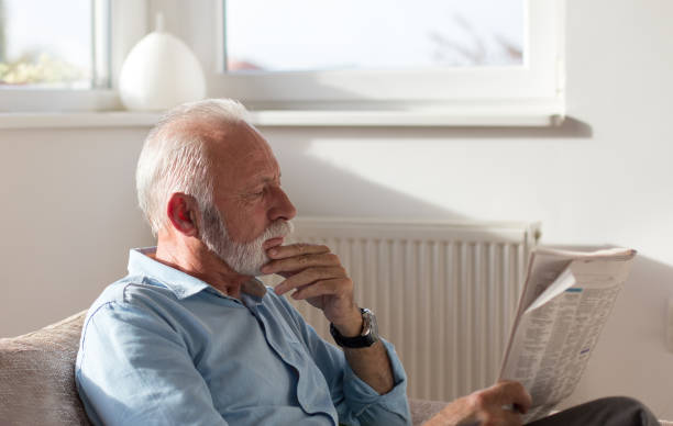 istock Senior man reading newspaper at home 1065902036