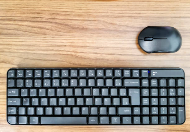 istock Keyboard and mouse over a wooden table 1065914524