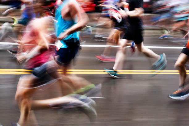 verschwommene aktion der marathonläufer auf stadtstraße - marathon stock-fotos und bilder