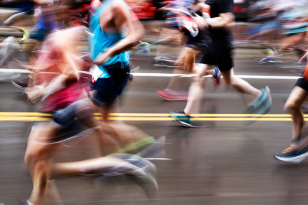 azione sfocata dei maratoneti su city street - maratona foto e immagini stock