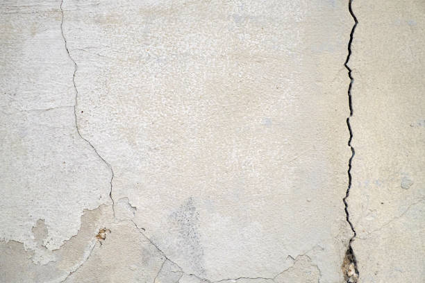 istock Old foundation and plaster wall with cracks. Building requiring repair closeup. 1065917622
