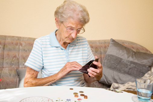 sad senior woman checking her money