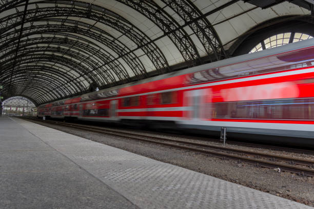 Beautiful railway station with modern high speed red commuter train with motion blur effect in Dresden, Germany.