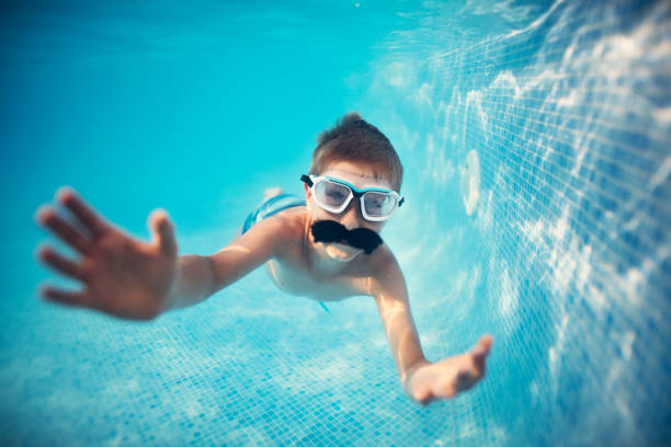 istock Cute little boy swimming underwater in pool 1065948340