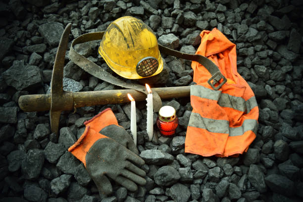 istock Vigil light, candle with the miner belongings (helmet, gloves, pickaxe, vest, belt) 1065950230