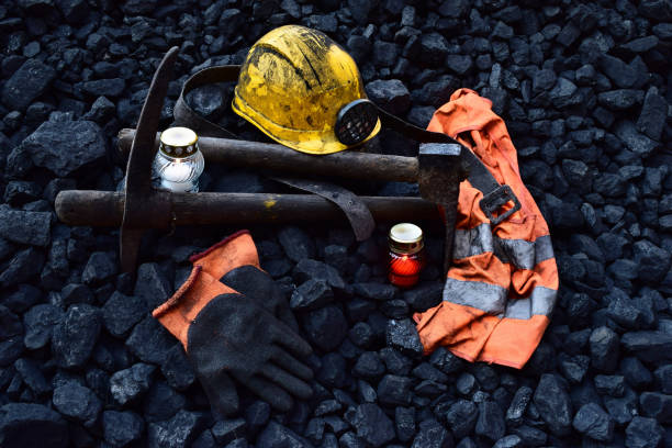 istock Vigil light, candle with the miner belongings (helmet, gloves, pickaxe, vest, belt) 1065952034