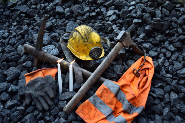 istock Vigil light, candle with the miner belongings (helmet, gloves, pickaxe, vest, belt) 1065952212
