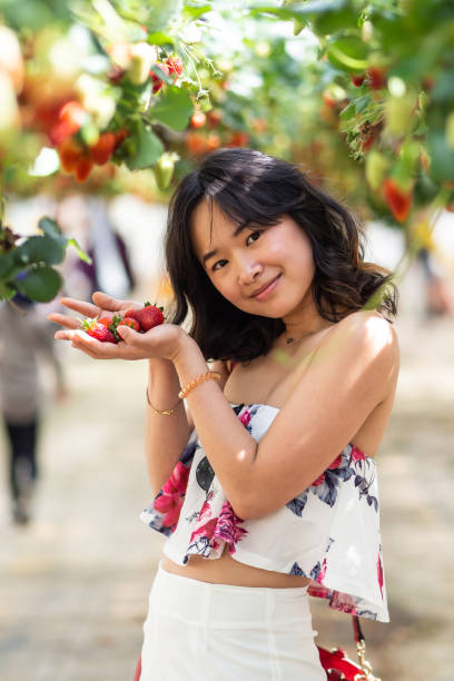 istock Young woman at a strawberry farm 1065960770