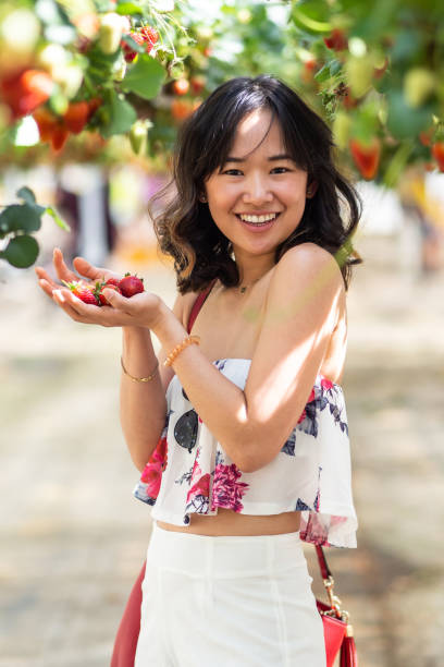 istock Young woman at a strawberry farm 1065960828