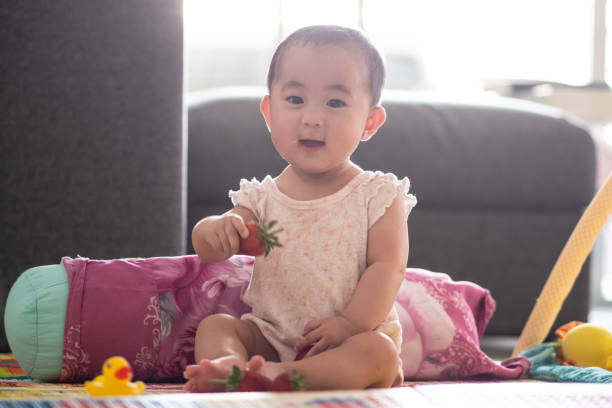 istock Cute 6 month old baby with strawberries 1065961200