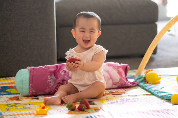 istock Cute 6 month old baby with strawberries 1065964054