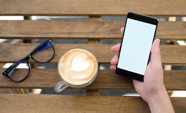 istock Phone in hand and a Cup of coffee. 1065978696