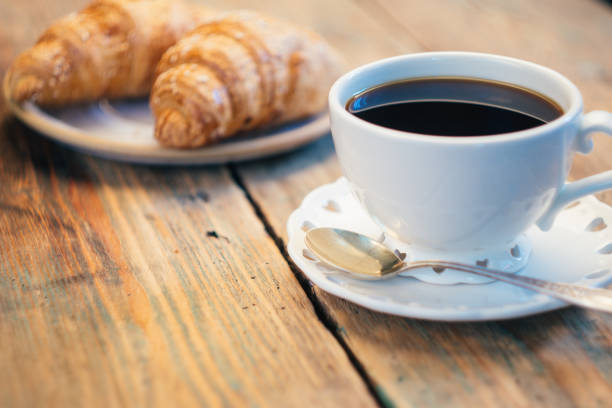 istock Black coffee and croissant. Typical French Breakfast (Petit DÃ©jeuner) background. 1065978866