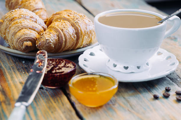 istock Black coffee and croissant with jam. Typical French Breakfast (Petit DÃ©jeuner) background. 1065978868