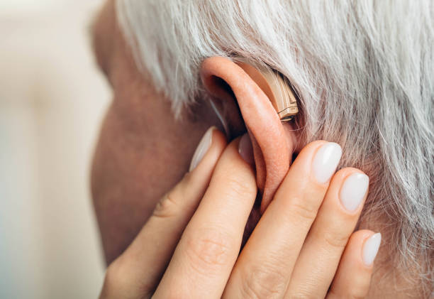 istock adjusting of a hearing aid for an aged man 1065982454