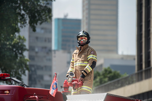 Rio de Janeiro, Rio de Janeiro, Brazil. 07th September 2016. Firefighter on top of fire truck wearing full combat suit with reflective glasses and helmet. Rio de Janeiro downtown emergency services.
