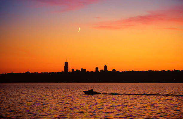 istock Kirkland to Seattle with Orange Sky, Setting Moon, and Boat. 1065995822