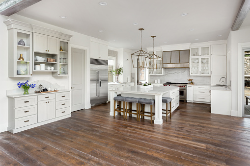 hermosa cocina en casa con isla, Lámparas colgantes y pisos de madera de lujo nuevo photo