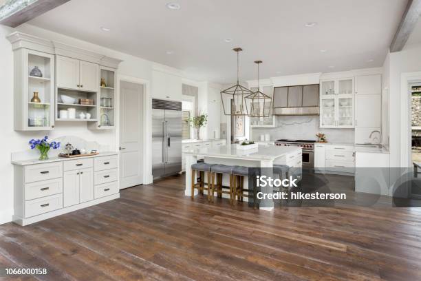 Beautiful Kitchen In New Luxury Home With Island Pendant Lights And Hardwood Floors Stock Photo - Download Image Now