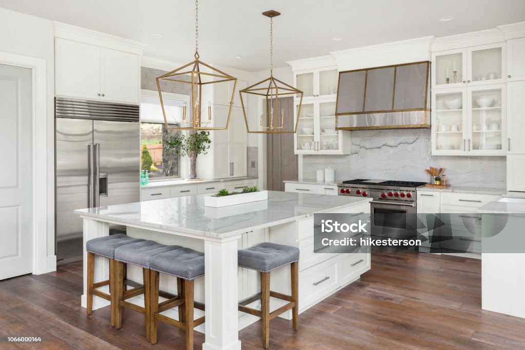 beautiful kitchen in new luxury home with island, pendant lights, and hardwood floors kitchen in newly constructed luxury home Kitchen Stock Photo