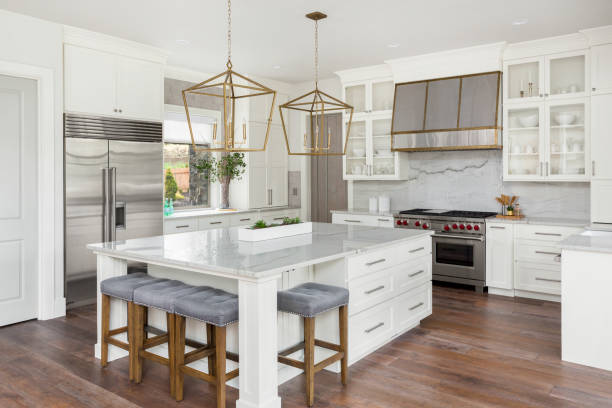 beautiful kitchen in new luxury home with island, pendant lights, and hardwood floors stock photo