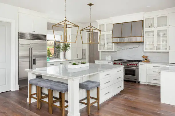 Photo of beautiful kitchen in new luxury home with island, pendant lights, and hardwood floors
