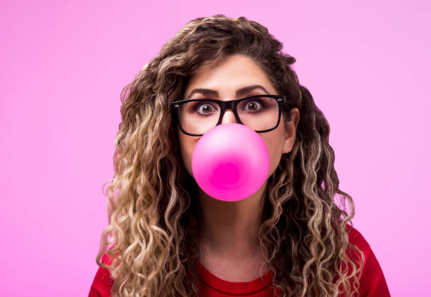 Beautiful young woman blowing a bubble gum balloon Beautiful young woman blowing a bubble gum balloon fish with big lips stock pictures, royalty-free photos & images