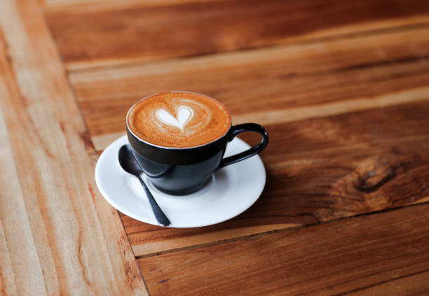 istock Cappuccino cup with heart latte art on wooden table background. 1066002266