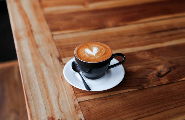 istock Cappuccino cup with heart latte art on wooden table background. 1066002268