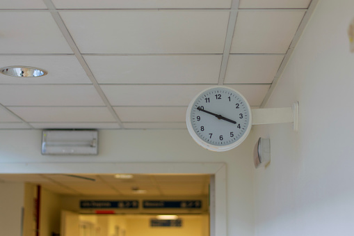 A white clock on a hospital wall