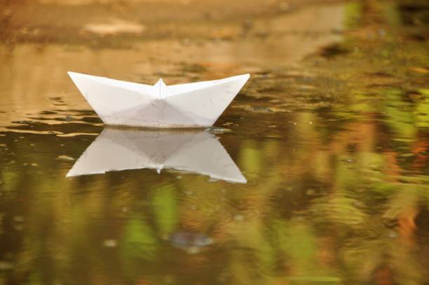 istock Paper boat in water 1066016256