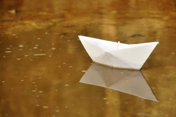 istock Paper boat in water 1066016278
