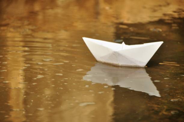 istock Paper boat in water 1066016284