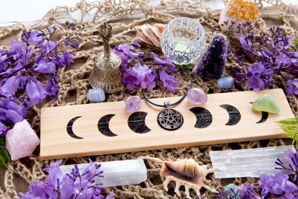 Full Moon Witch Pagan Altar decorations with Moon Phases, crystals, purple flowers and pentacle pendant Full Moon Witch Pagan Moon Phases Altar with crystals of selenite and amethyst, with candle, pentacle and purple flowers religious service photos stock pictures, royalty-free photos & images