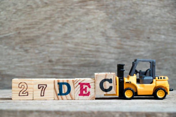 istock Toy forklift hold block c to complete word 27dec on wood background (Concept for calendar date 27 in month December) 1066035356