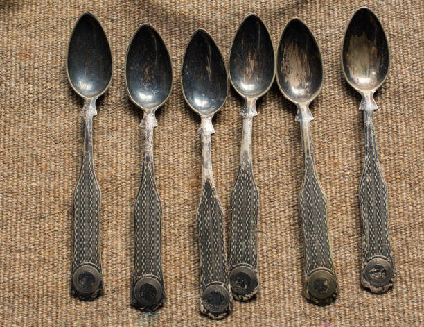 Stylish steel teaspoons on a textured background