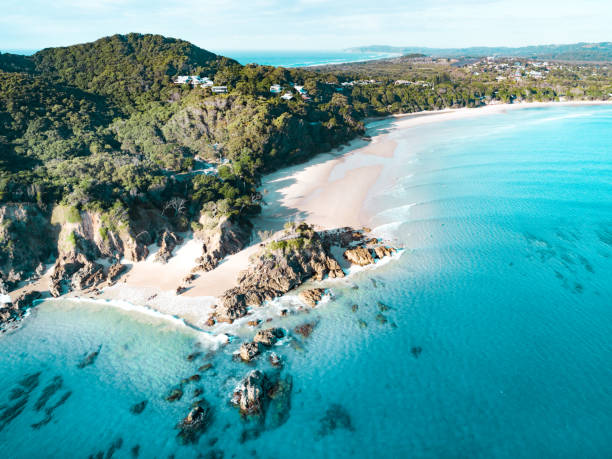 Aerial view of a beach and water. Aerial view of a beach at sunrise, waves and beautiful blue, turquoise water byron bay stock pictures, royalty-free photos & images