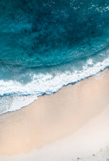 Aerial view of a beach and water. Aerial view of a beach at sunrise, waves and beautiful blue, turquoise water Victoria Bay stock pictures, royalty-free photos & images