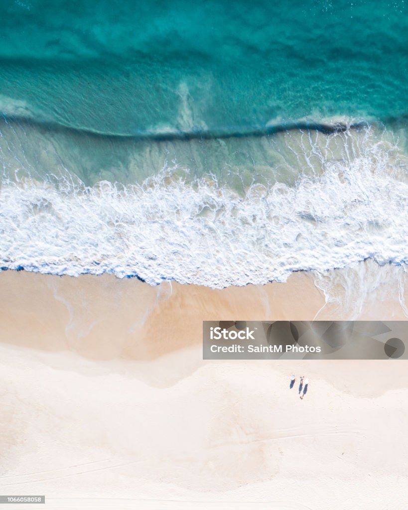 Aerial view of a beach and water. Aerial view of a beach at sunrise, waves and beautiful blue, turquoise water Beach Stock Photo