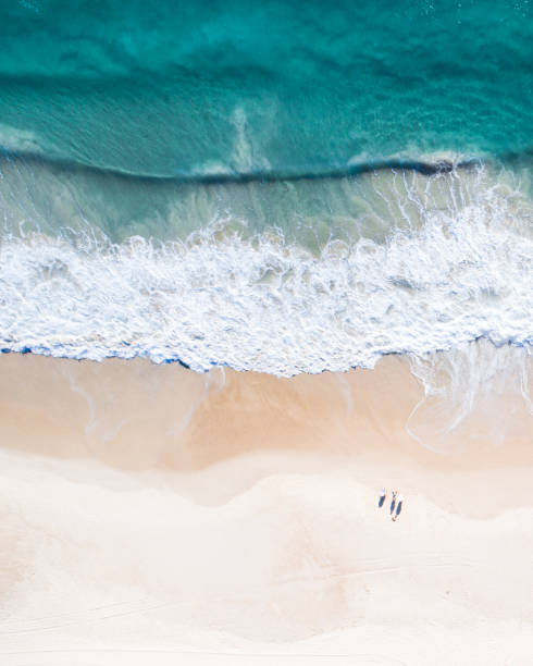 Aerial view of a beach and water. Aerial view of a beach at sunrise, waves and beautiful blue, turquoise water sydney sunset stock pictures, royalty-free photos & images