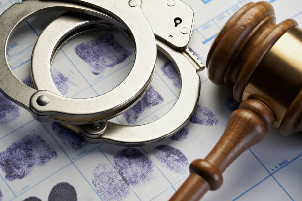 istock Gavel and handcuffs on fingerprints: Arrest crime concept 1066060592