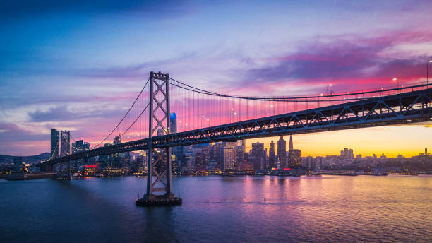 vue aérienne de paysage urbain de san francisco et le bay bridge avec coucher de soleil coloré, californie, é.-u. - san francisco oakland bay bridge photos et images de collection