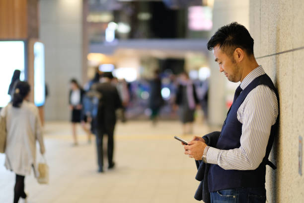 istock Businessman watching smart phone on street at night 1066065440