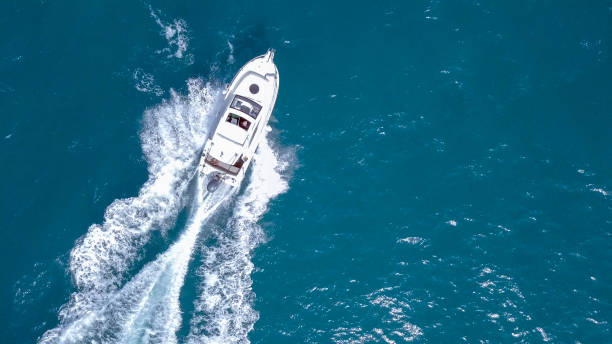 Speedboat roaring across the Mediterranean Sea Speedboat roaring across the Mediterranean Sea - Top down aerial image fast boat stock pictures, royalty-free photos & images